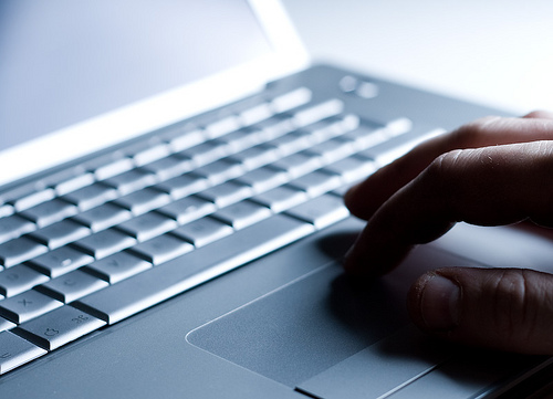 imatge art&iacute;stica amb una ma que escriu en un laptop